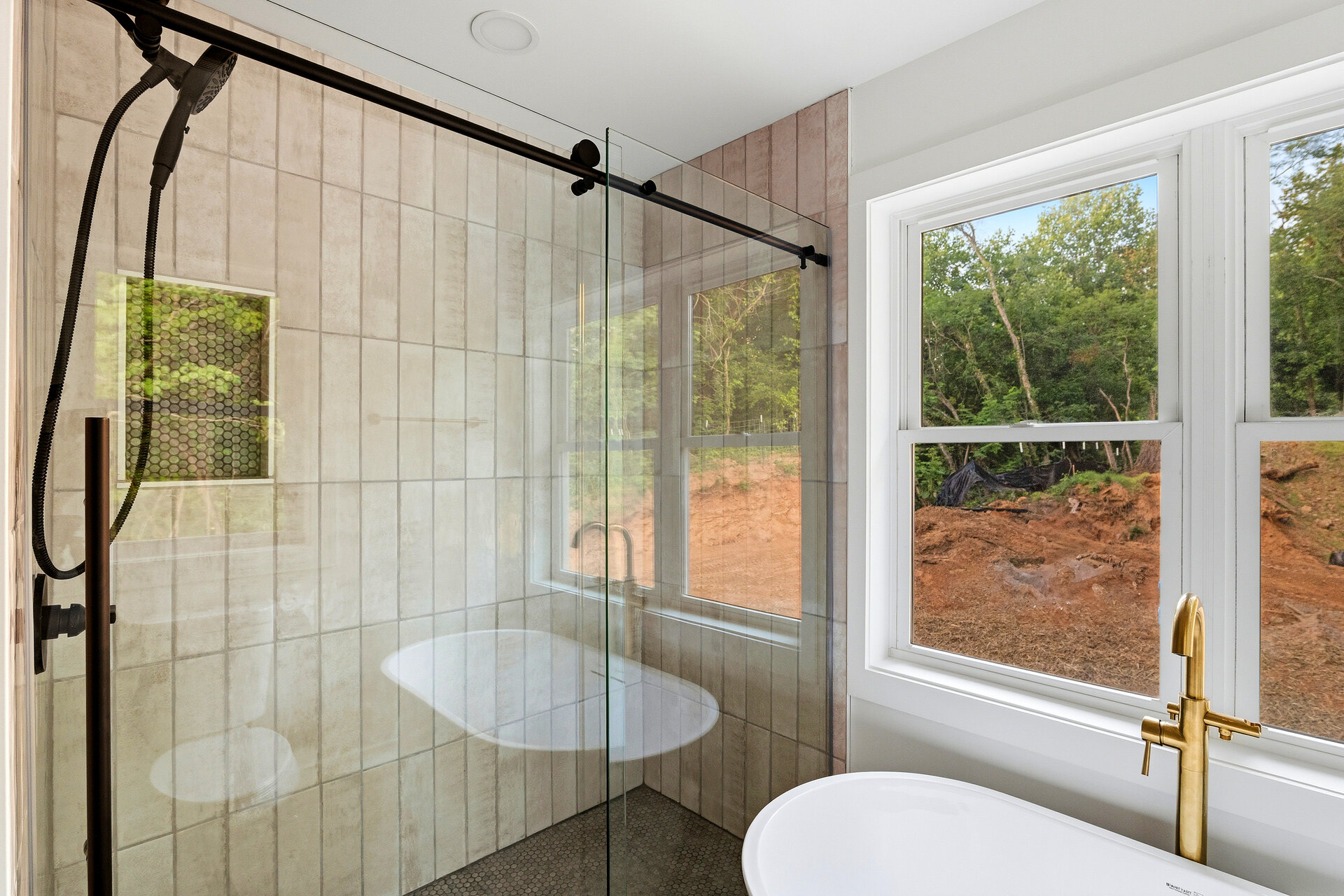 Walk-in tile shower next to a freestanding soaking tub in a remodeled Asheville primary bathroom